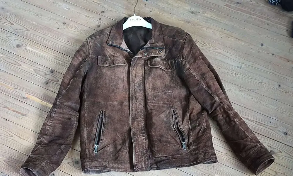 distressed brown leather jacket on floor